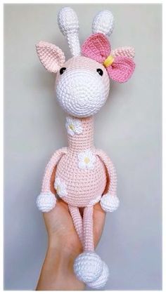 a crocheted giraffe with a pink bow on its head