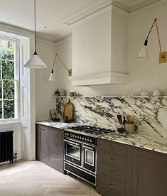 a kitchen with marble counter tops and stainless steel stove top ovens in the center