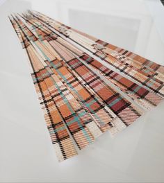 four pieces of woven fabric are arranged on top of each other, with different colors and patterns