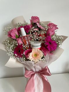 a bouquet of pink flowers and baby's breath are wrapped in white paper with a pink ribbon