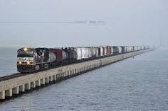 a train is traveling on the tracks over water