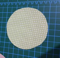 a piece of paper that has been cut into circles on a cutting mat with scissors