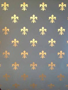 a blue wall with gold fleur de lis on it