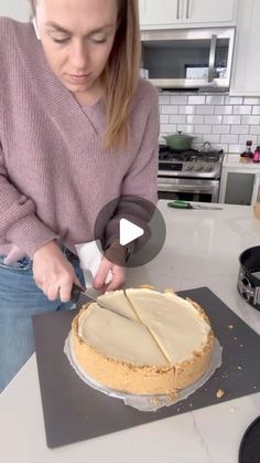 a woman cutting into a cake on top of a kitchen counter next to an oven