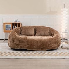 a living room filled with furniture and a large brown bean bag chair on top of a rug