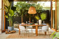 an outdoor dining area with table, chairs and potted plants