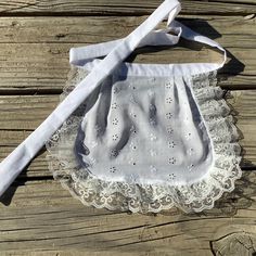 a white baby's diaper on top of a wooden table next to a tie