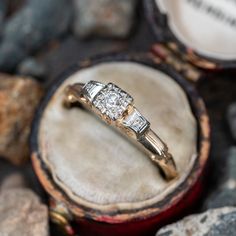 an engagement ring sitting on top of a wooden box