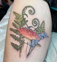 a mushroom with leaves and flowers on the thigh