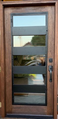 a wooden door with glass and metal bars