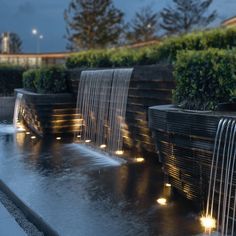 a water fountain with lights on it in the evening