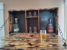 a wooden table with two glasses and bottles on it