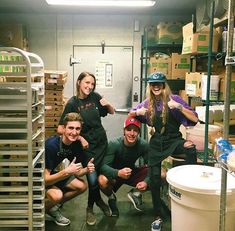 some people are posing for a photo in a storage room with boxes and other items