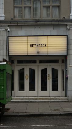 the entrance to a movie theater with white doors