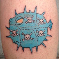 a tattoo on the leg of a man with skulls and bones around it, all in blue