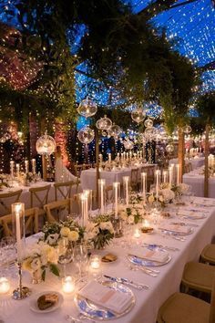 a long table is set up with candles and centerpieces for an elegant dinner