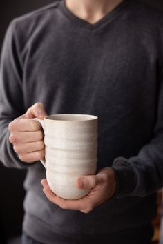 a person holding a coffee cup in their hands