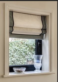 a window sill with a vase and bowl on it