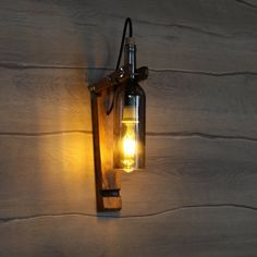 a light that is on the side of a wooden wall with a glass bottle in it