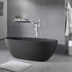 a bathroom with a large black bath tub