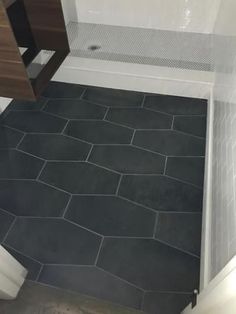 a bathroom with black tile flooring and white walls