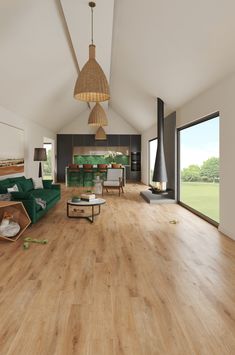 a large open living room with wood flooring and green couches in the center