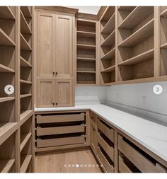 an empty kitchen with wooden cabinets and white counter tops in front of the pantry doors