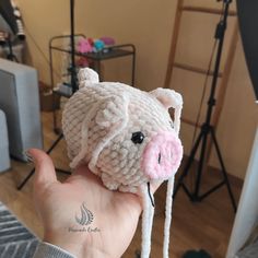 a hand holding a small knitted pig