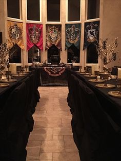 a room filled with tables covered in black cloths and decorated with harry potter flags