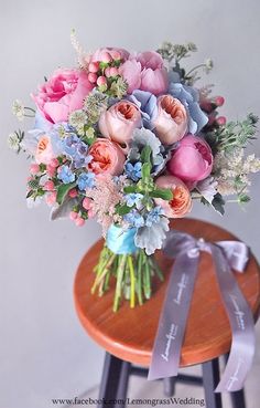 a bouquet of flowers sitting on top of a wooden table next to a ribbon tied around it