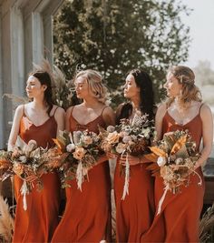 the bridesmaids are wearing orange dresses and holding bouquets in their hands while standing outside