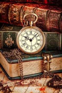 an old pocket watch sitting on top of some books