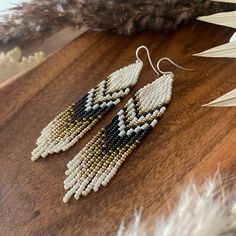 Elevate your everyday style with these exquisite beaded earrings featuring a cascading fringe. Each earring is meticulously crafted from a delicate blend of small, shimmering beads, creating a mesmerizing interplay of light and color. The elongated fringe delicately sways with every movement, adding a touch of whimsy and elegance to your ensemble. Whether you're dressing for an elegant occasion or enjoying a casual day out, these earrings will seamlessly complement your style. These beaded earri Beaded Fringe Earrings Pattern, Bohemian Beaded Beige Earrings, Bohemian Brown Beaded Fringe Earrings, Brown Beaded Fringe Dangle Earrings, Bohemian Hand-strung Beaded Earrings, Gold Artisan Beaded Fringe Earrings, Beaded Jewelry Earrings, Beaded Lanyards, Homemade Jewelry