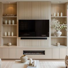 a living room filled with furniture and a flat screen tv mounted on a wall above a fireplace