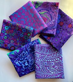 six purple and blue cloths on a white surface