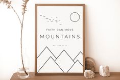 a poster with the words, faith can move mountains written on it next to some rocks