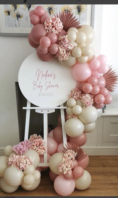 the balloon arch is decorated with pink and white balloons