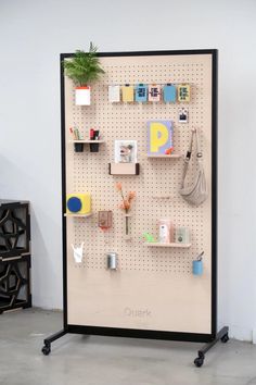 there is a pegboard with many items on it and a potted plant in the corner