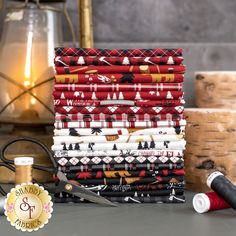 a stack of red and white fabric next to a pair of scissors on a table