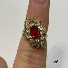 Vintage "Dinner Ring" with red gem in center surrounded by clear gems. Vintage ring inventory form my great grandmother's restaurant and gift shop in Silverton, CO that she owned and operated from the 1960s to 1996. Style V6 Sizes available: Size 6 - qty 1 Red Ruby Cluster Ring With Rose Cut Diamonds, Vintage Red Ring For Anniversary, Red Victorian Diamond Ring, Red Crystal Ring With Stone Setting For Anniversary, Red Diamond Cluster Ring, Red Oval Cluster Ring With Rose Cut Diamonds, Oval Jeweled Rings For Weddings, Oval Jeweled Wedding Rings, Vintage Red Crystal Round Ring