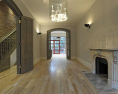 an empty room with wood floors and a chandelier