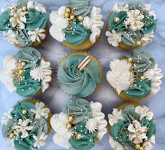 cupcakes decorated with blue and white frosting on a marble counter top,