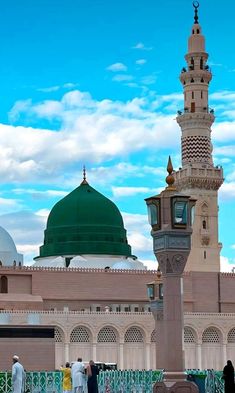 two men standing in front of a large building with a green dome on the top