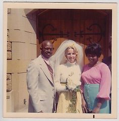 two women and a man standing in front of a church door