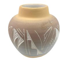 a brown and white vase with designs on the outside, sitting in front of a white background