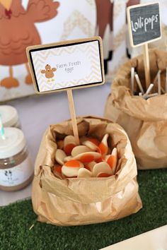 two bags filled with candy sitting on top of a green tablecloth covered floor next to a sign