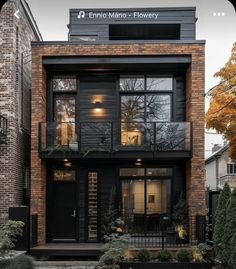 an image of a modern house with black doors and glass windows on the second floor