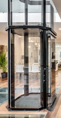 the inside of a house with glass walls and wood flooring is shown in this photo