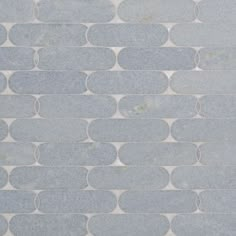 a white and blue tile wall with circles on the bottom, in an irregular pattern