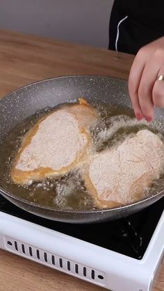 someone is frying some food in a pan on the stove